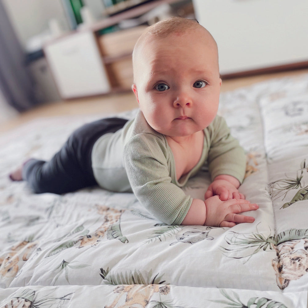 Baby auf Krabbeldecke